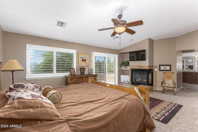 bedroom featuring ceiling fan, carpet, connected bathroom, a multi sided fireplace, and vaulted ceiling