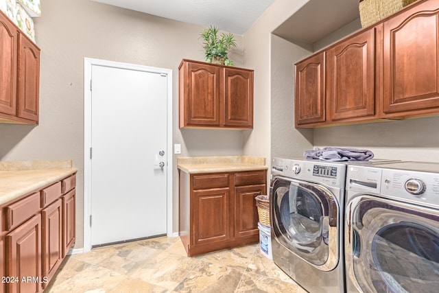 washroom with cabinets and washing machine and clothes dryer