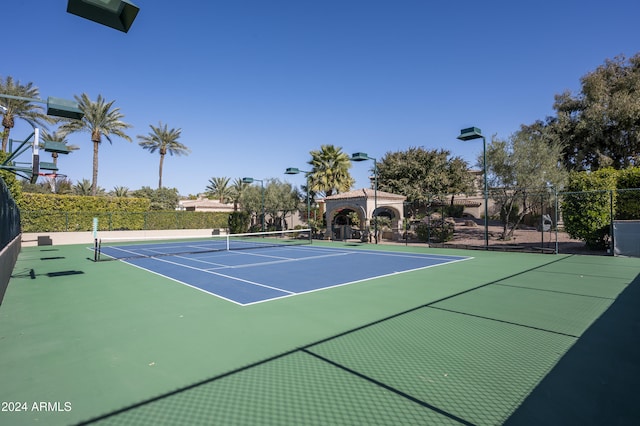 view of tennis court with a gazebo and basketball hoop