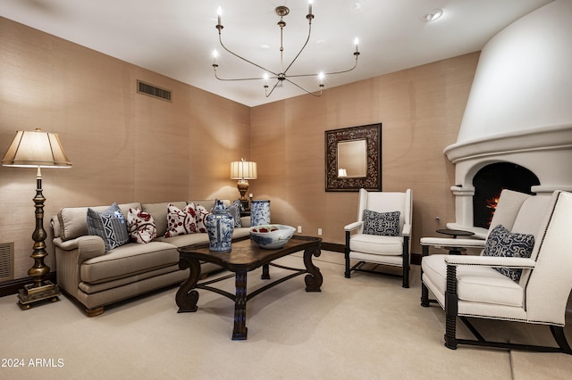 carpeted living room featuring a large fireplace and a chandelier