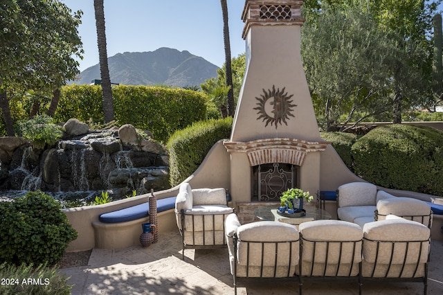 view of patio / terrace featuring a mountain view and exterior fireplace