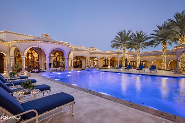 pool at dusk with a patio