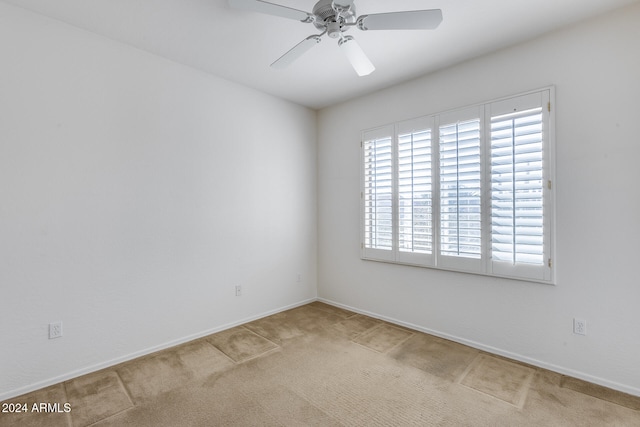 carpeted spare room with ceiling fan