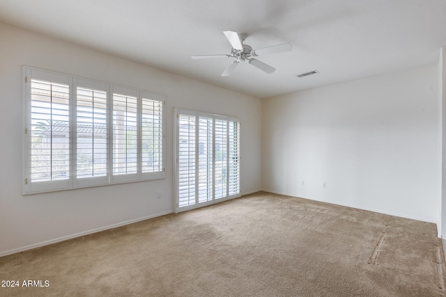 carpeted spare room with ceiling fan