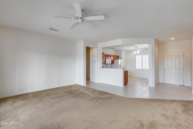 unfurnished living room featuring ceiling fan and light tile patterned floors