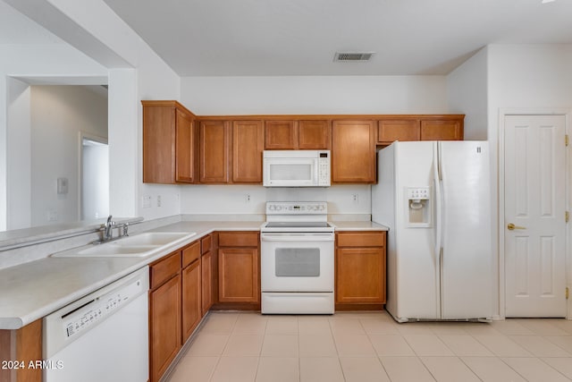 kitchen with kitchen peninsula, white appliances, sink, and light tile patterned floors