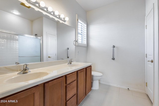 bathroom with tile patterned flooring, vanity, toilet, and a shower with door