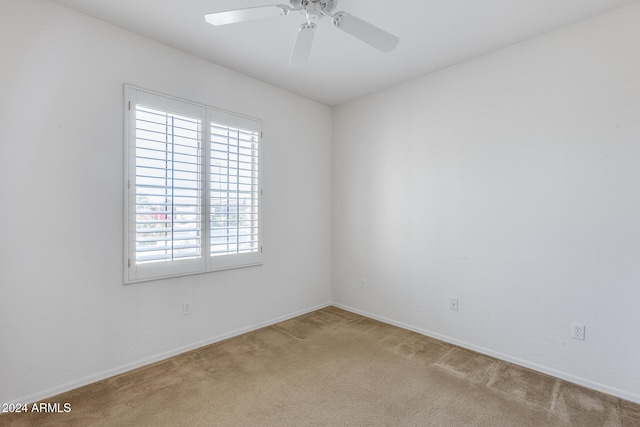 carpeted spare room featuring ceiling fan