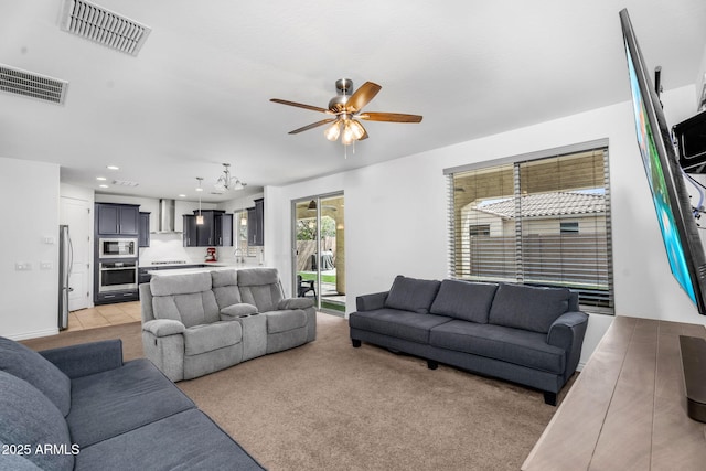 living area featuring a ceiling fan, light carpet, and visible vents