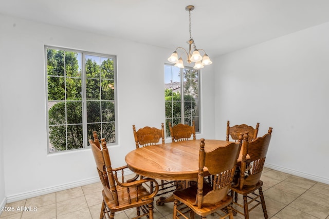 dining room with an inviting chandelier, light tile patterned floors, and baseboards