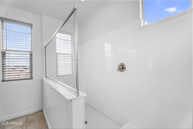 bathroom with a wealth of natural light, tile patterned flooring, and walk in shower