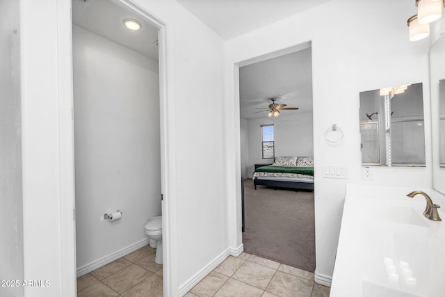 bathroom with ceiling fan, toilet, tile patterned floors, connected bathroom, and a sink