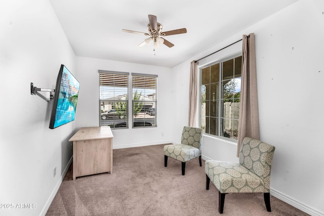 living area with baseboards, carpet flooring, and ceiling fan