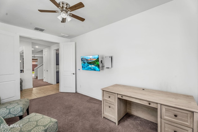 office area with visible vents, baseboards, ceiling fan, light carpet, and light tile patterned floors