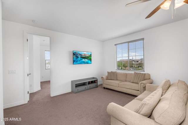 living room with a ceiling fan, carpet floors, and baseboards