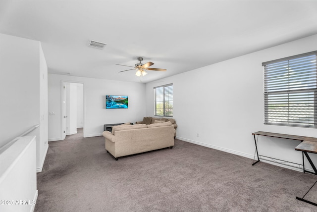 carpeted living area featuring baseboards, ceiling fan, and visible vents