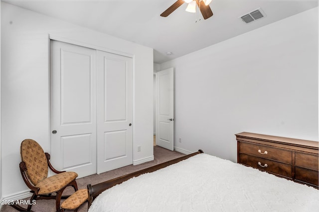 bedroom with a closet, carpet flooring, a ceiling fan, baseboards, and visible vents