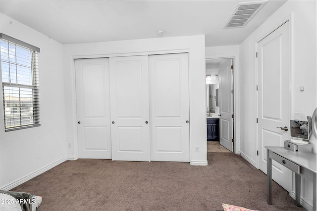 bedroom with a closet, visible vents, and carpet
