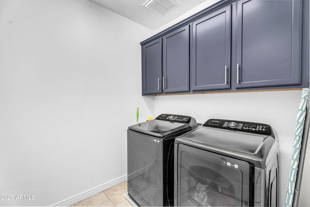 washroom with light tile patterned flooring, washing machine and dryer, baseboards, visible vents, and cabinet space