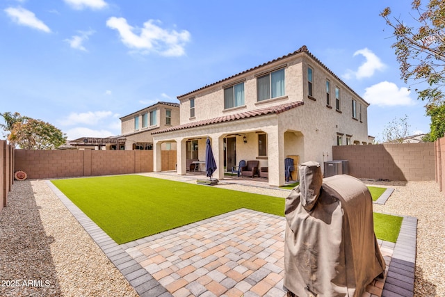 rear view of house with central air condition unit, a fenced backyard, a tile roof, stucco siding, and a patio area