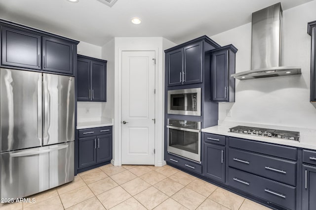 kitchen featuring wall chimney exhaust hood, light countertops, light tile patterned floors, and stainless steel appliances