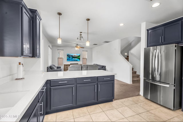 kitchen featuring open floor plan, light countertops, freestanding refrigerator, a ceiling fan, and a peninsula