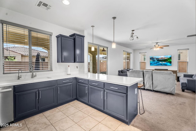 kitchen featuring visible vents, a peninsula, a ceiling fan, a sink, and stainless steel dishwasher