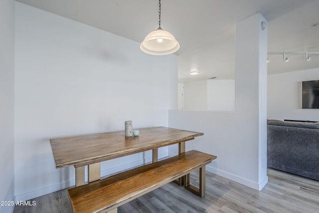 dining room featuring track lighting and light hardwood / wood-style floors