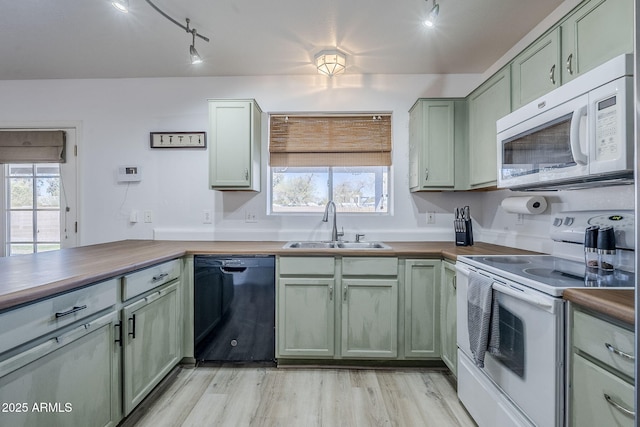 kitchen featuring white appliances, wooden counters, sink, and green cabinetry