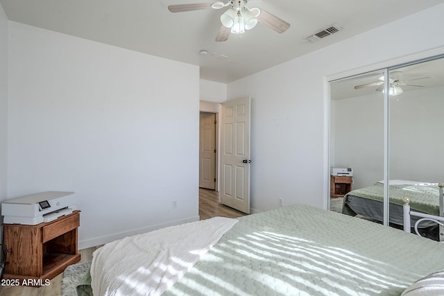 bedroom with ceiling fan, a closet, and light hardwood / wood-style flooring