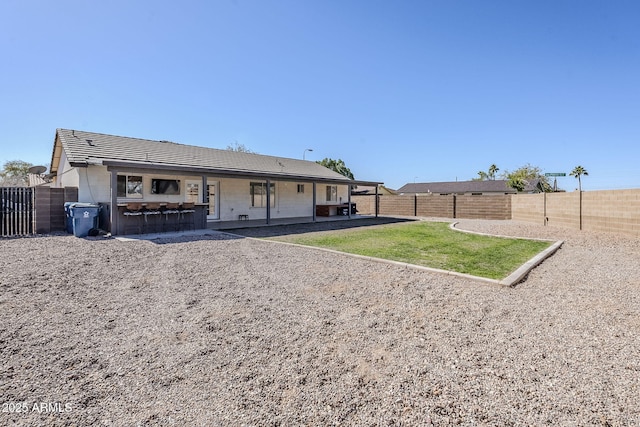 rear view of property featuring a patio area and a bar