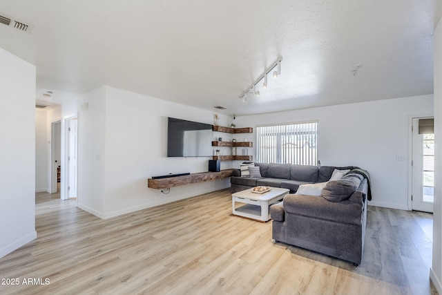 living room with a healthy amount of sunlight and light hardwood / wood-style flooring