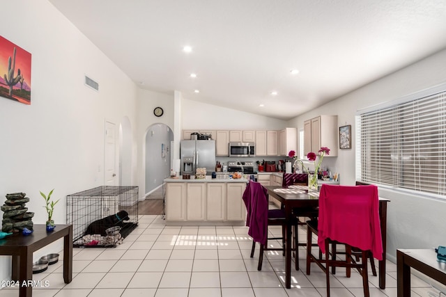 dining area featuring light tile patterned flooring and vaulted ceiling