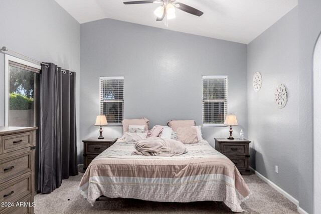 carpeted bedroom with multiple windows, ceiling fan, and vaulted ceiling