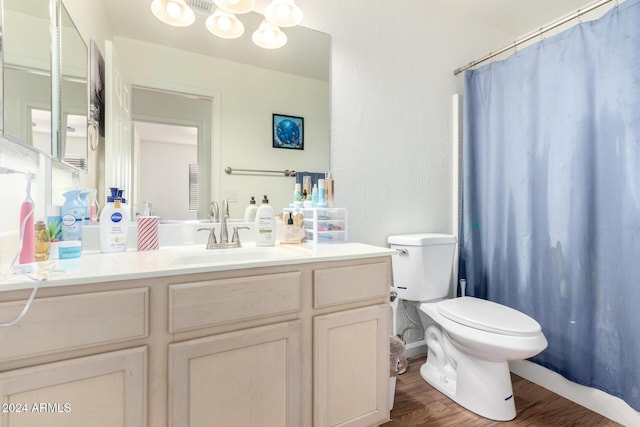 bathroom with wood-type flooring, vanity, toilet, and walk in shower