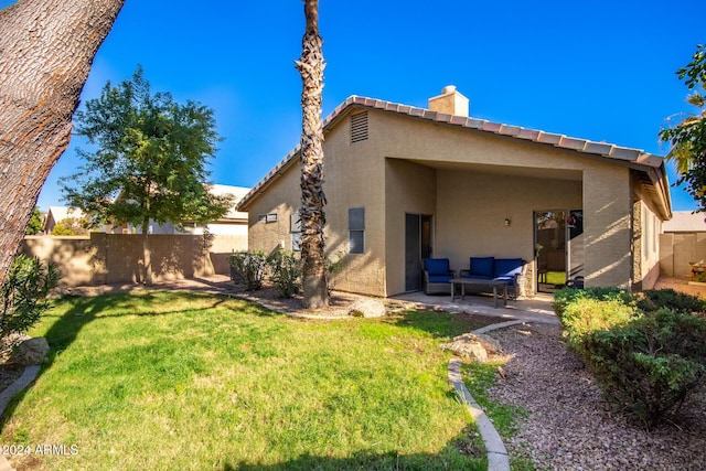 back of property featuring a lawn, an outdoor living space, and a patio