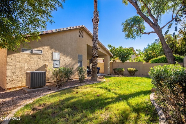 view of home's exterior with a yard and central AC