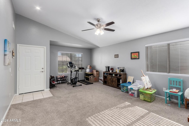 exercise room with ceiling fan, light colored carpet, and lofted ceiling