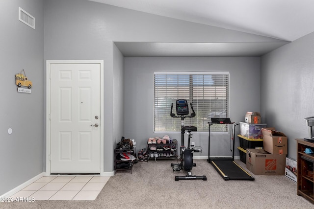 workout room featuring light carpet and vaulted ceiling