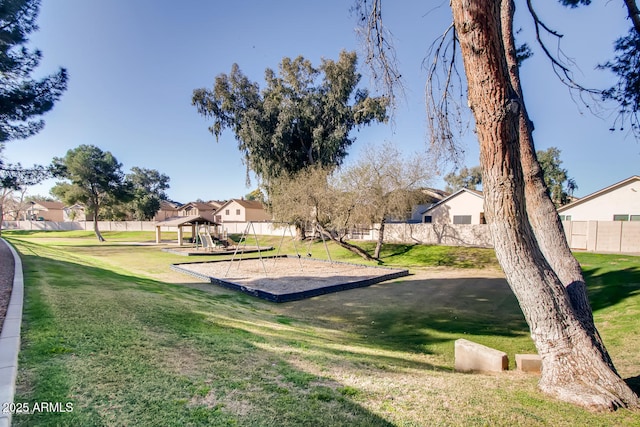 surrounding community featuring playground community, a lawn, and fence