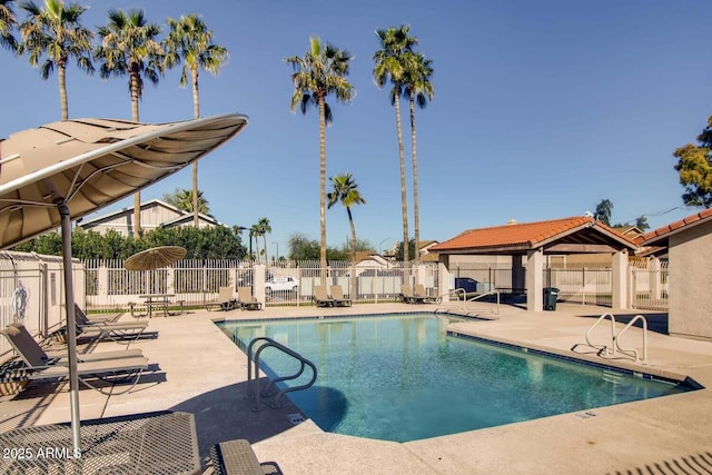 community pool featuring fence, a gazebo, and a patio