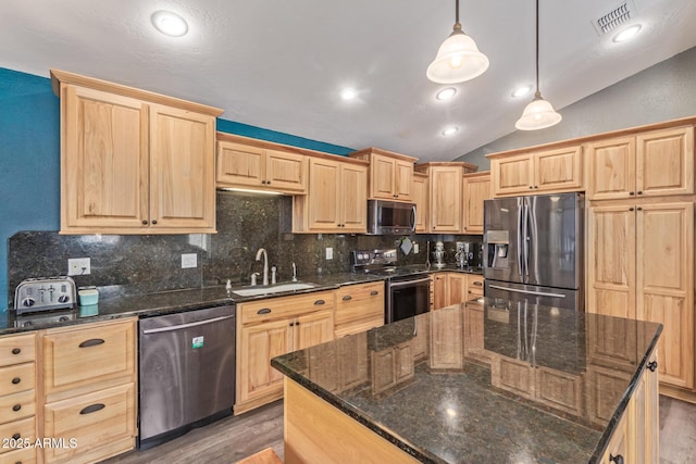 kitchen with visible vents, appliances with stainless steel finishes, vaulted ceiling, light brown cabinets, and a sink