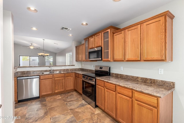 kitchen featuring lofted ceiling, ceiling fan with notable chandelier, hanging light fixtures, sink, and appliances with stainless steel finishes