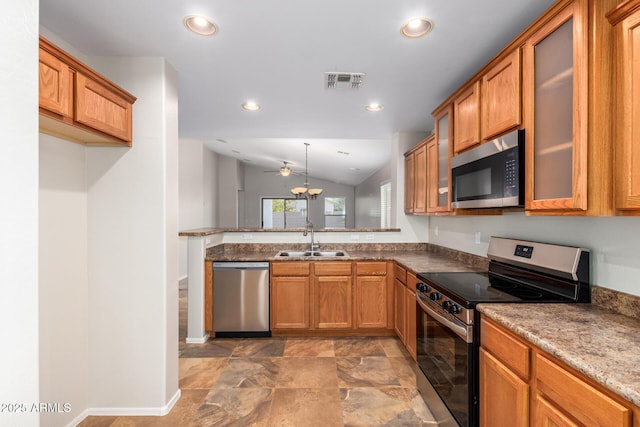 kitchen with light stone countertops, sink, ceiling fan, vaulted ceiling, and appliances with stainless steel finishes