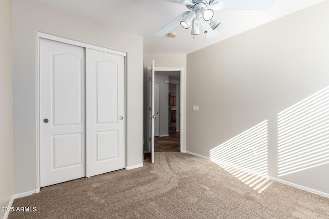 unfurnished bedroom featuring carpet, ceiling fan, and a closet