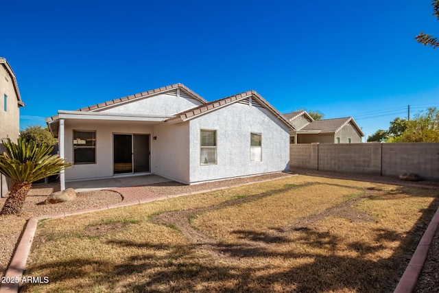 back of house featuring a yard and a patio