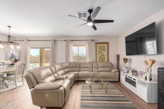 living room featuring hardwood / wood-style floors and ceiling fan with notable chandelier