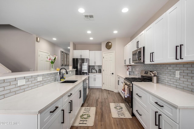 kitchen with appliances with stainless steel finishes, white cabinetry, and sink