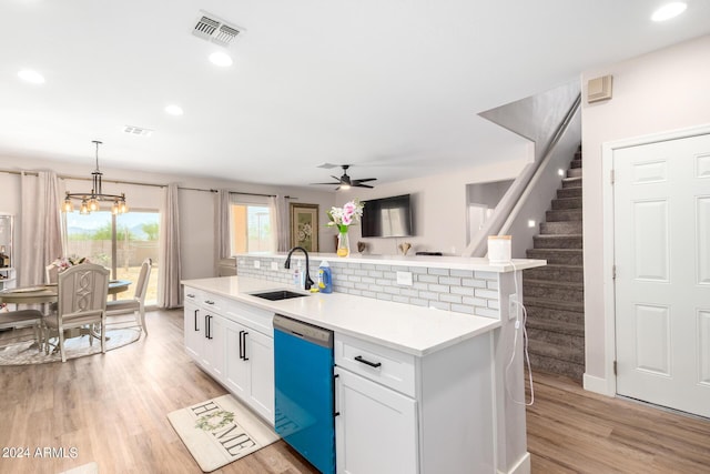 kitchen with stainless steel dishwasher, ceiling fan with notable chandelier, sink, decorative light fixtures, and white cabinets