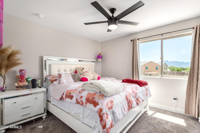 carpeted bedroom with ceiling fan and a mountain view